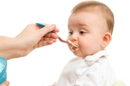 baby being fed homemade porridge by mommy