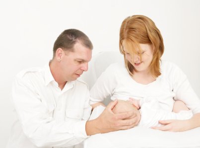 What are the Benefits of Breastfeeding? 8 mom breastfeeding baby with dad providing support